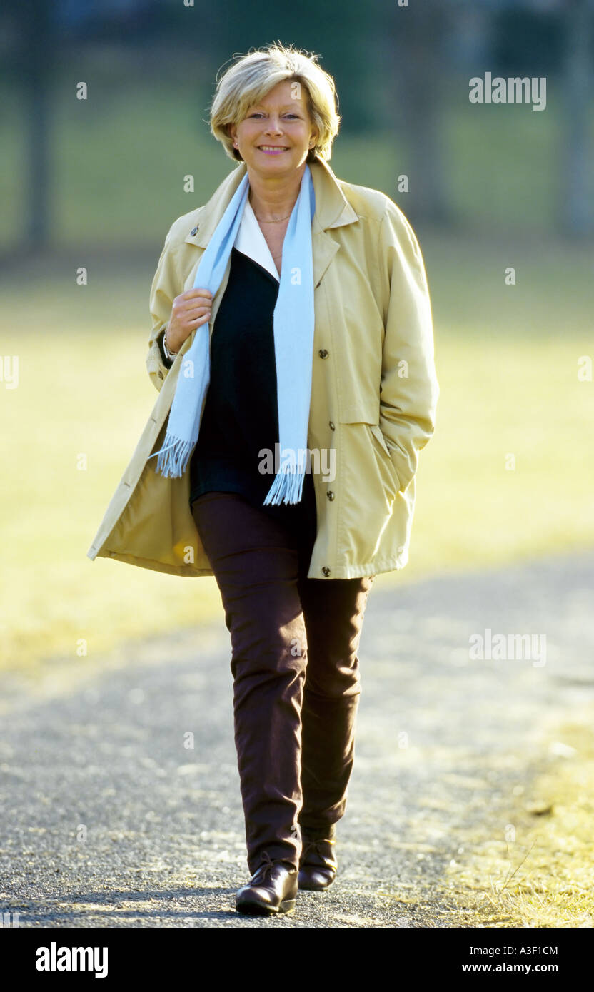 Mature blonde woman walking looking at camera Stock Photo