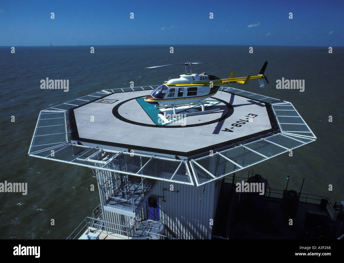 Bell Jet Ranger helicopter on offshore oil rig landing platform in