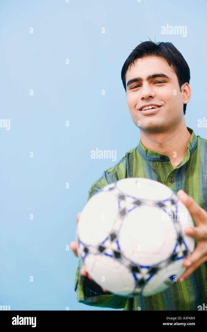 Portrait of a young man holding a soccer ball and smiling Stock Photo ...