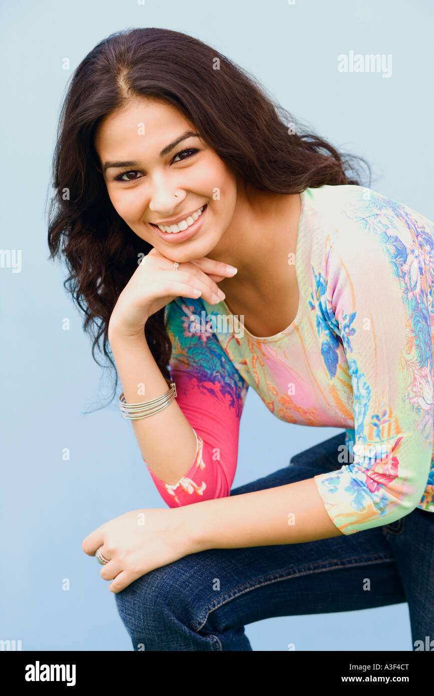 Portrait of a young woman smiling with her hand on her chin Stock Photo ...