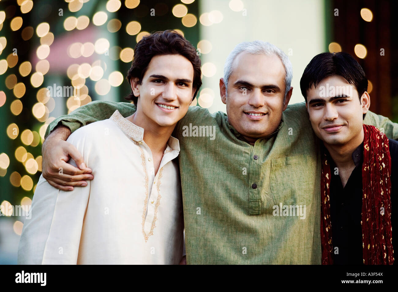 Portrait of a mid adult man standing with two young men Stock Photo - Alamy