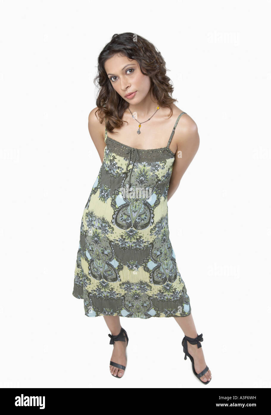 Portrait of a young woman standing with her hands behind her back Stock ...