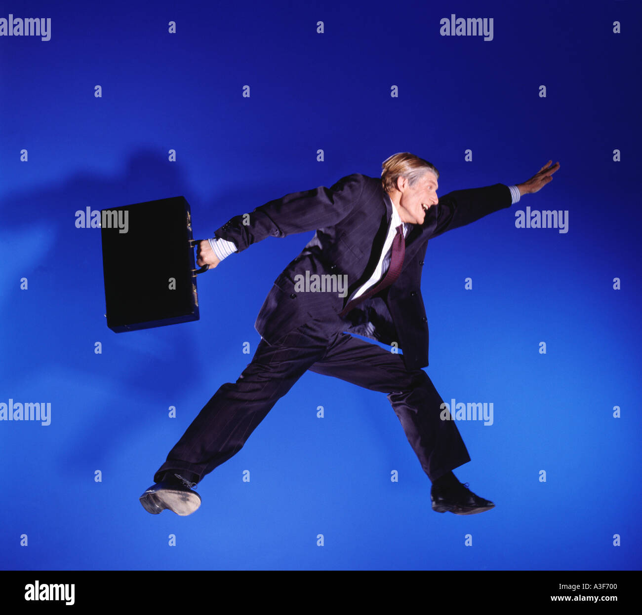 business man jumping in the air blue background Stock Photo