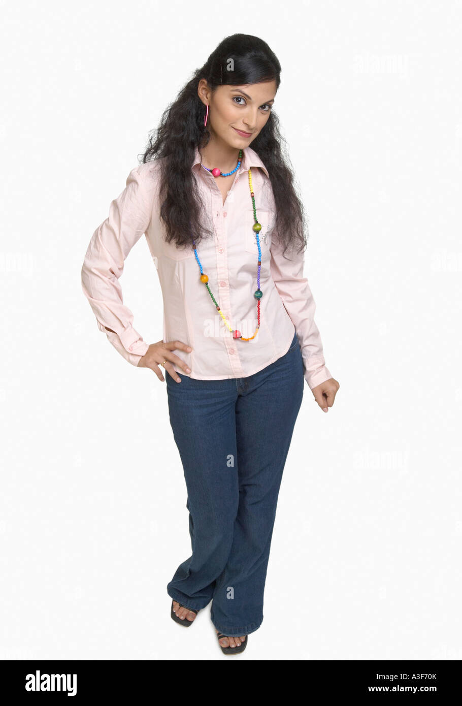 Portrait of a young woman standing with her hand on hip Stock Photo - Alamy