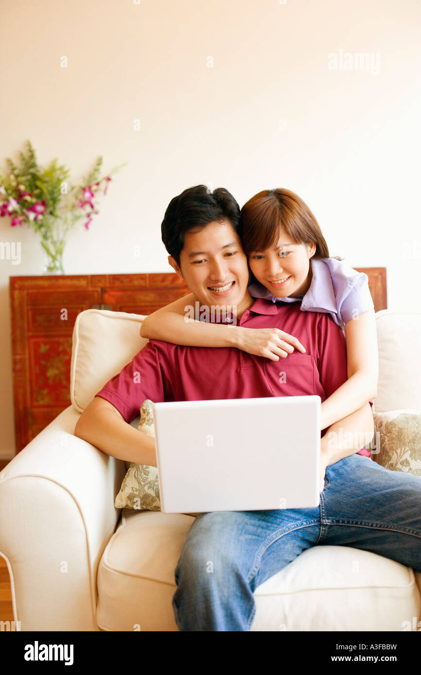 Young couple using a laptop and smiling Stock Photo - Alamy