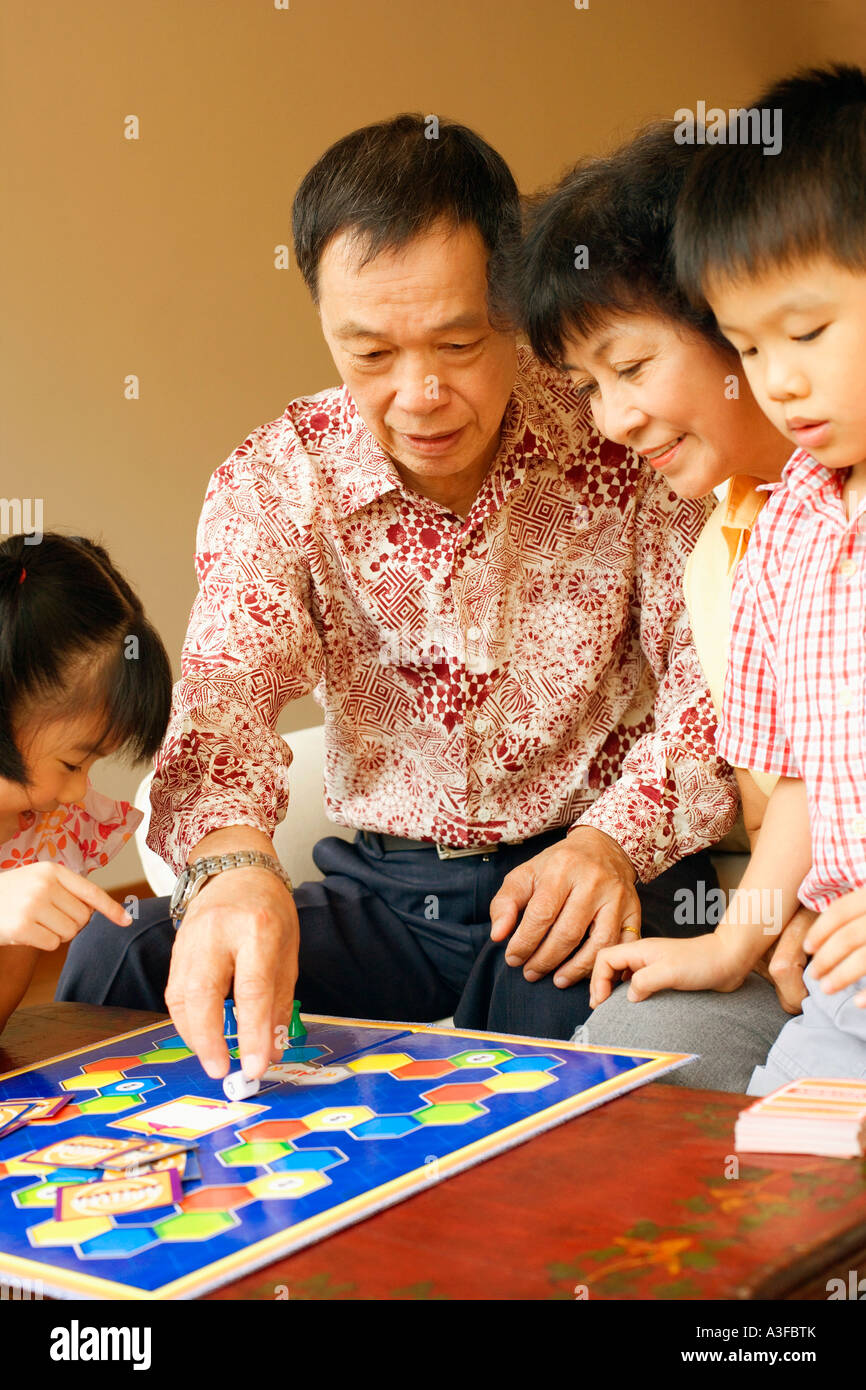 Close-up of a girl and a boy playing a game with their grandparents Stock Photo