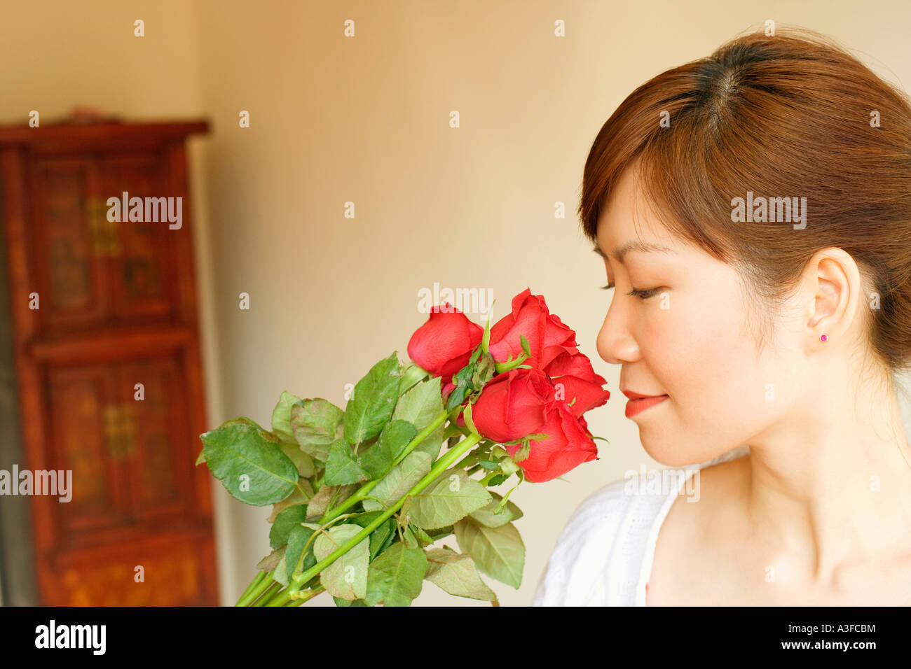 Side profile of a young woman smelling flowers Stock Photo - Alamy