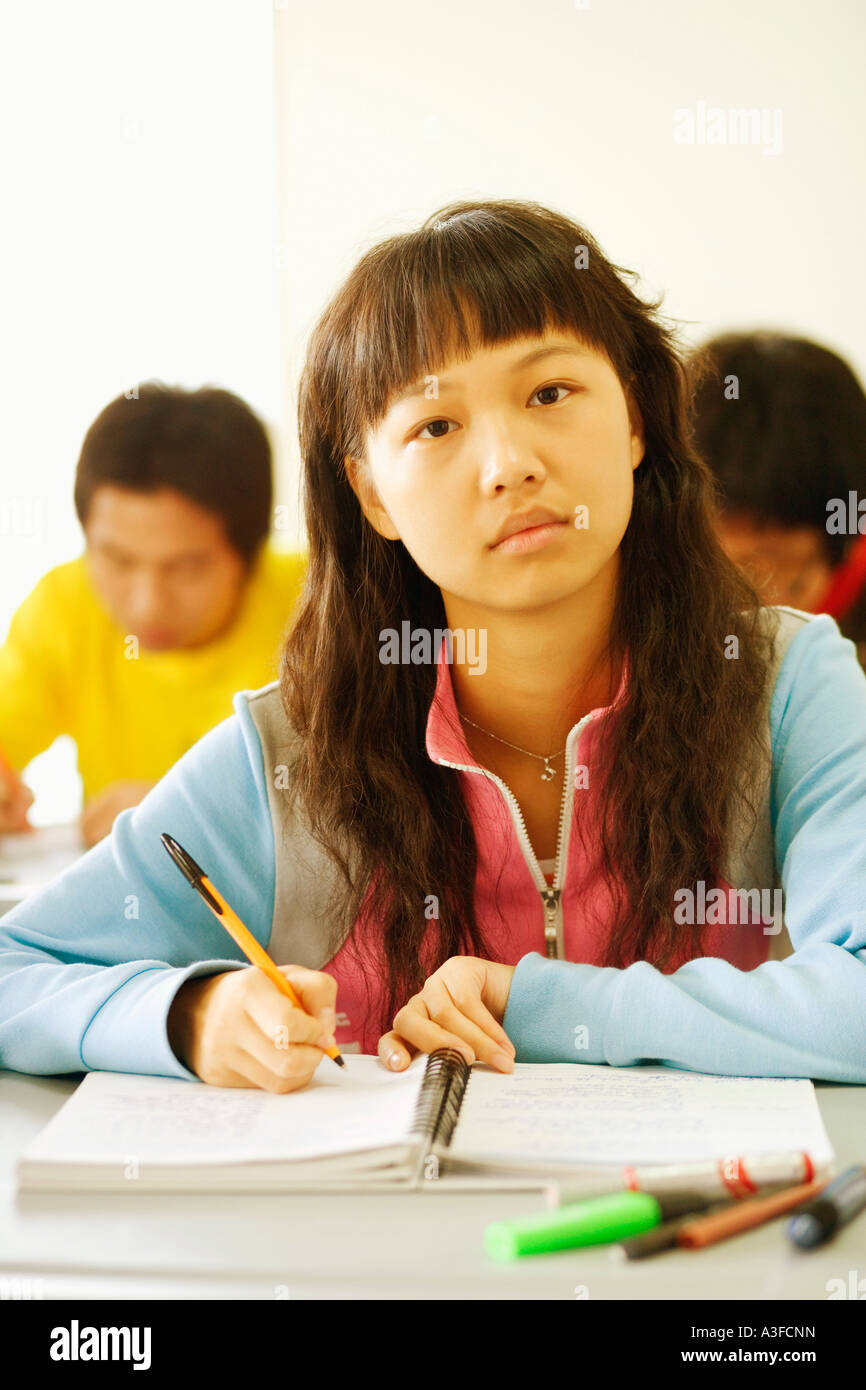 Portrait of a young woman sitting at a desk in the classroom Stock ...