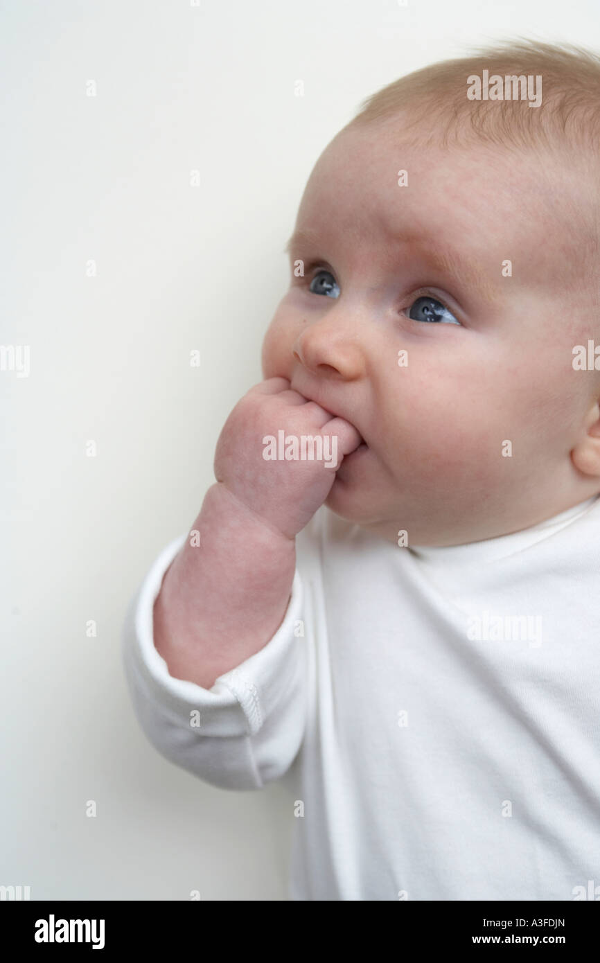 Baby with hand in mouth Stock Photo