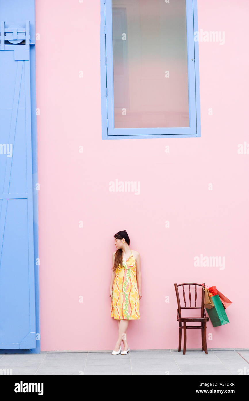 Young woman standing beside a chair Stock Photo