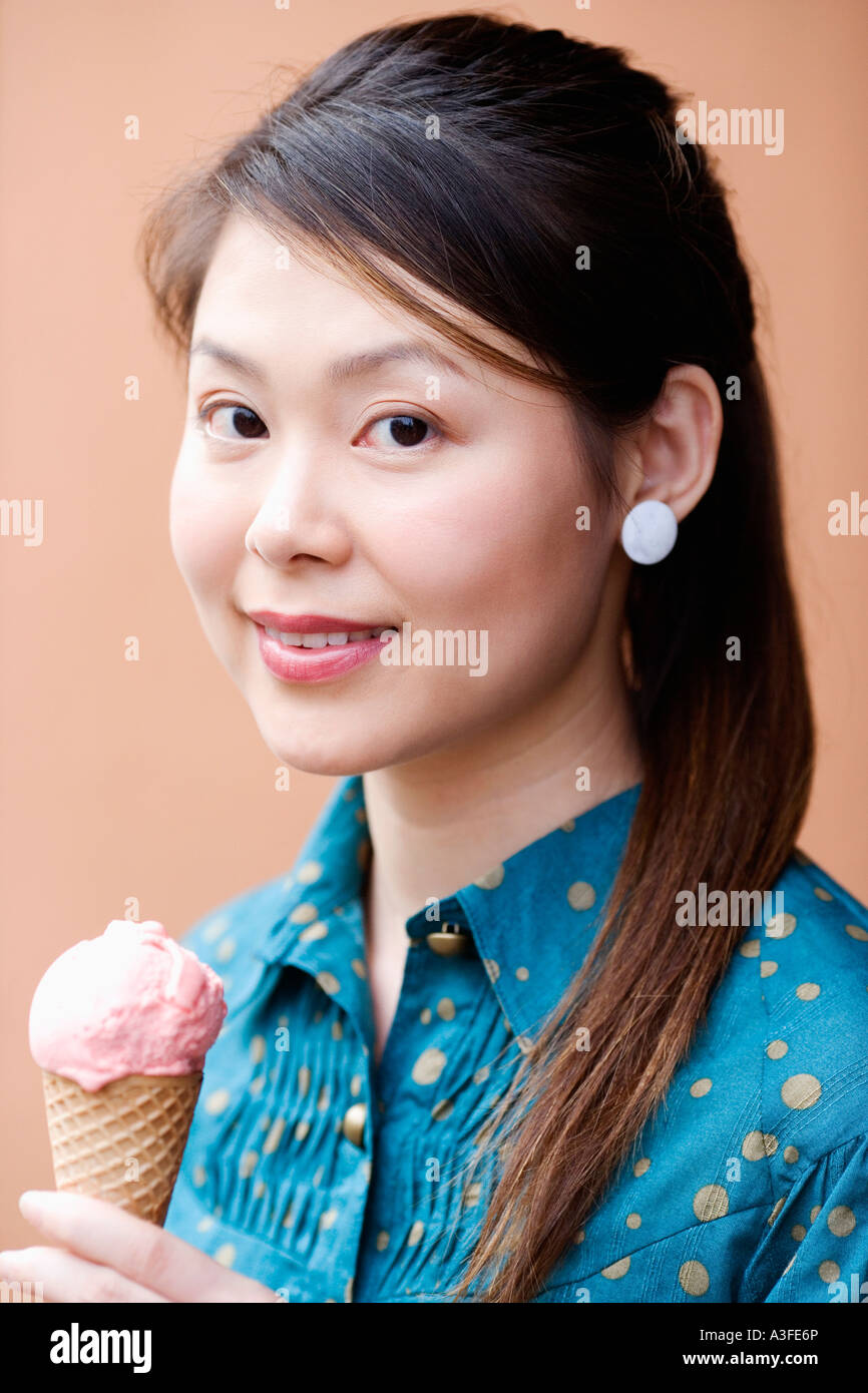 Portrait of a young woman holding an ice-cream cone Stock Photo