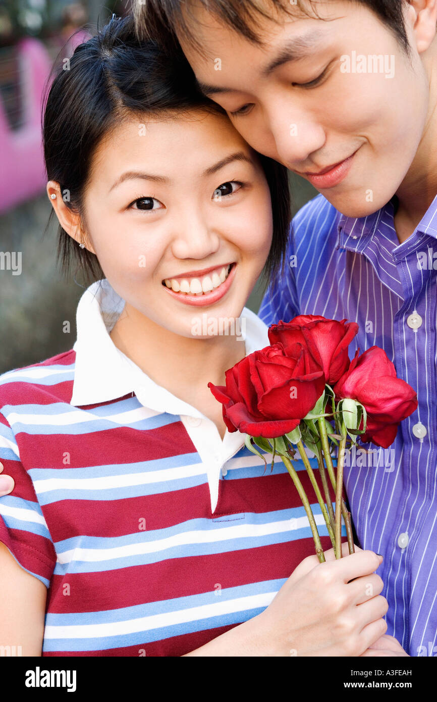 Close-up of a young couple holding a bunch of roses Stock Photo