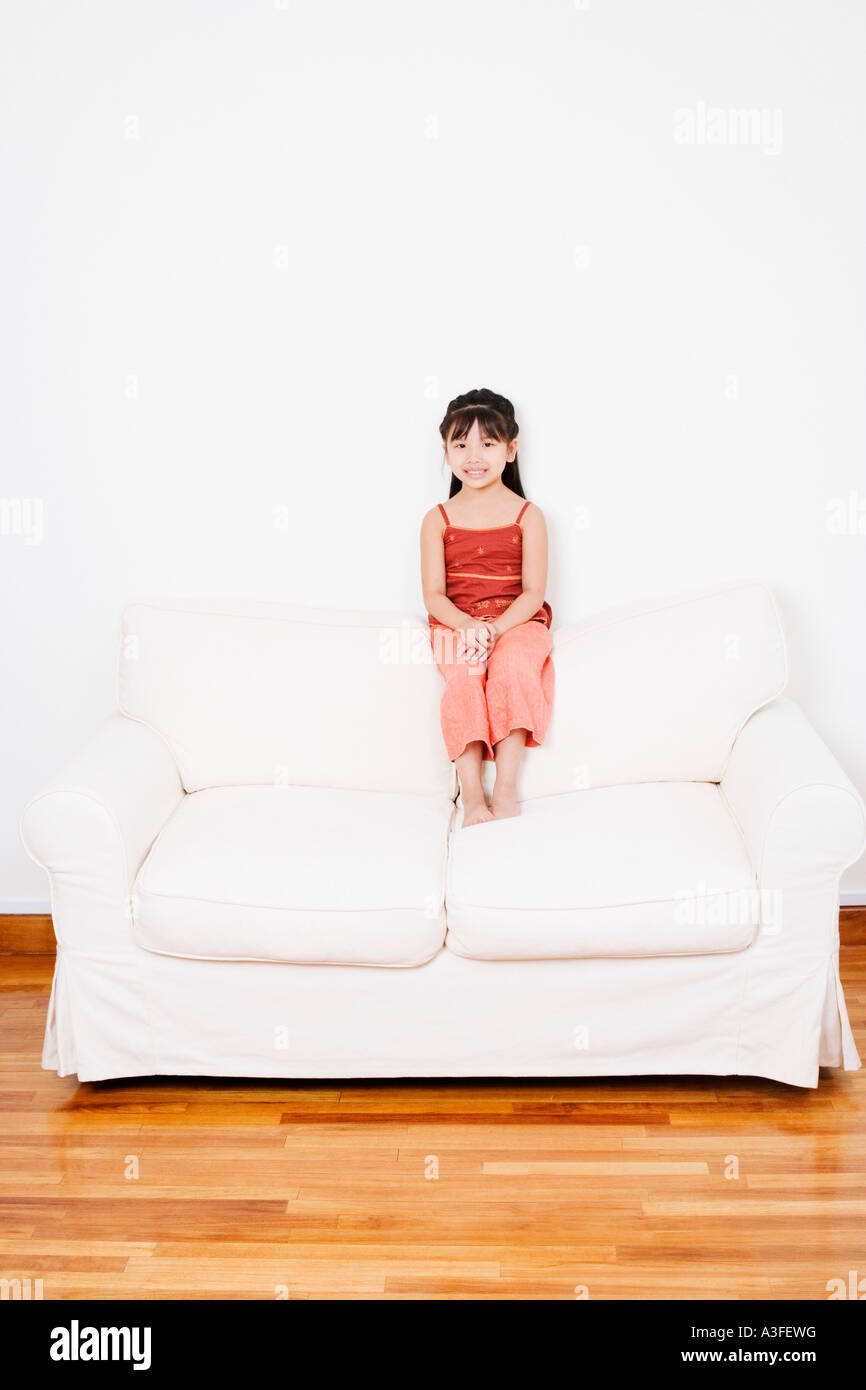 Portrait of a girl sitting on a couch Stock Photo - Alamy