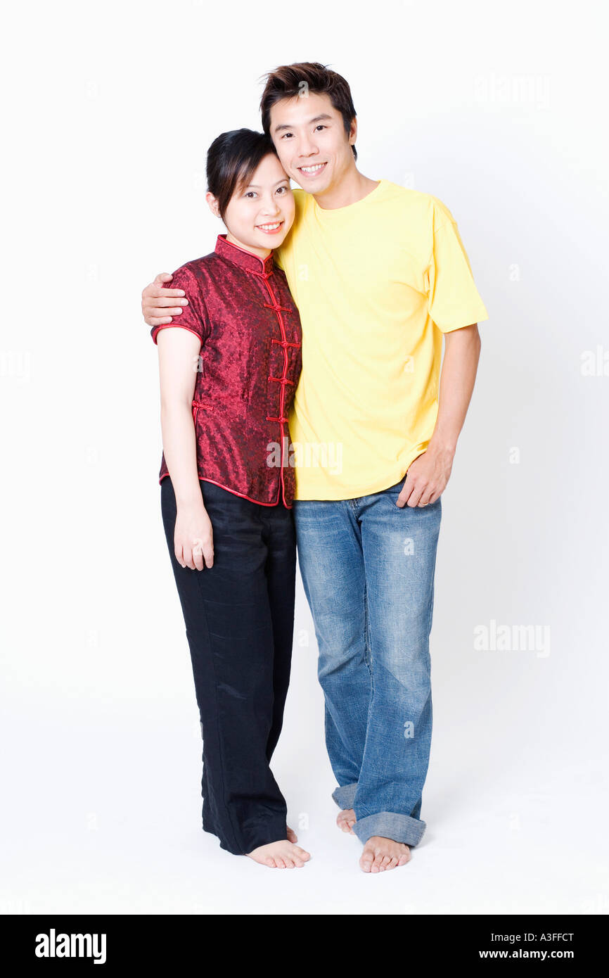 Portrait of a mid adult man standing with his arm around a young woman and smiling Stock Photo