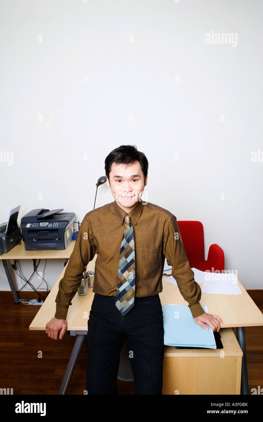 Portrait of a businessman smiling and standing in an office Stock Photo ...
