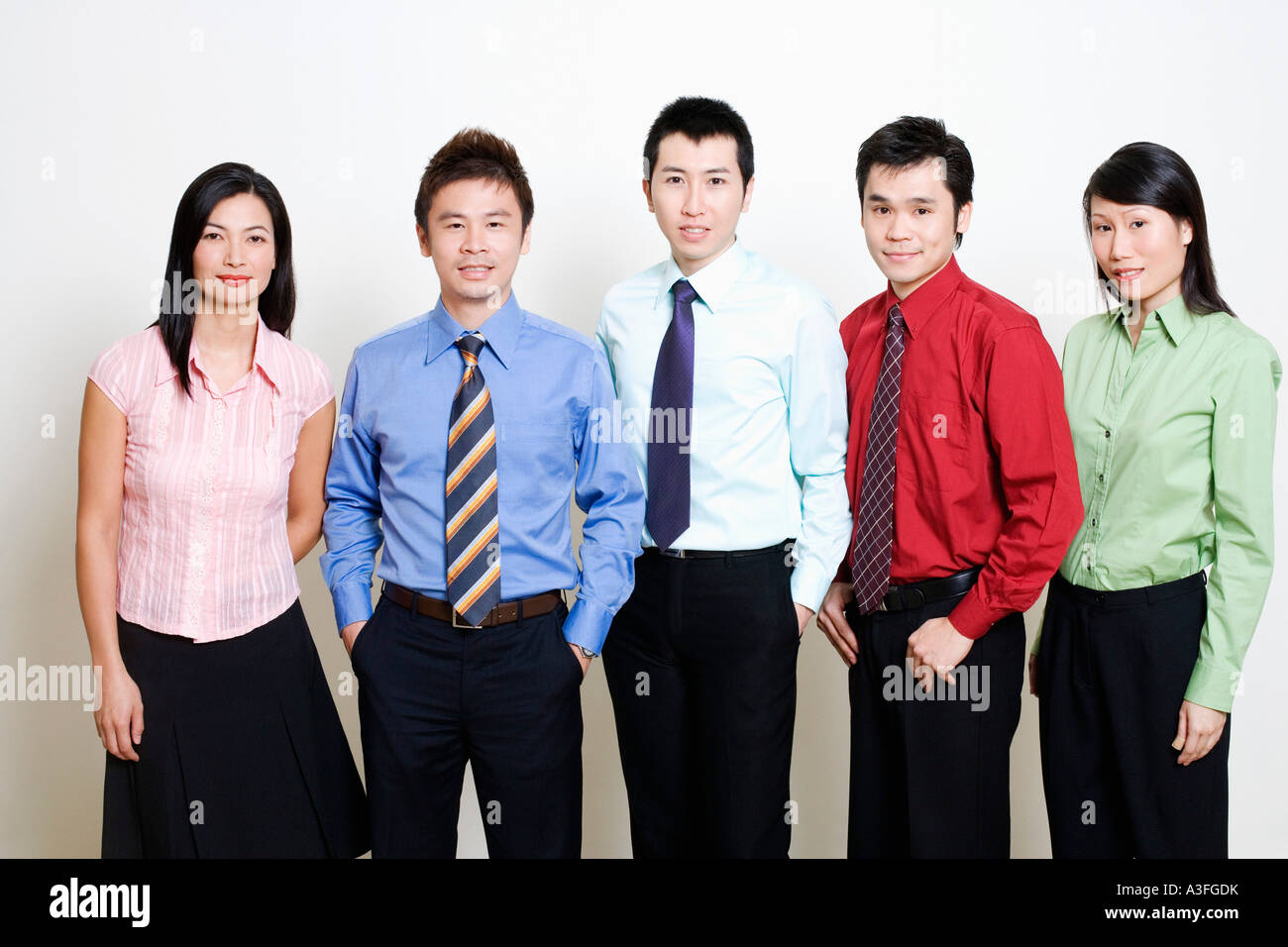 Portrait of five business executives standing and smiling together ...
