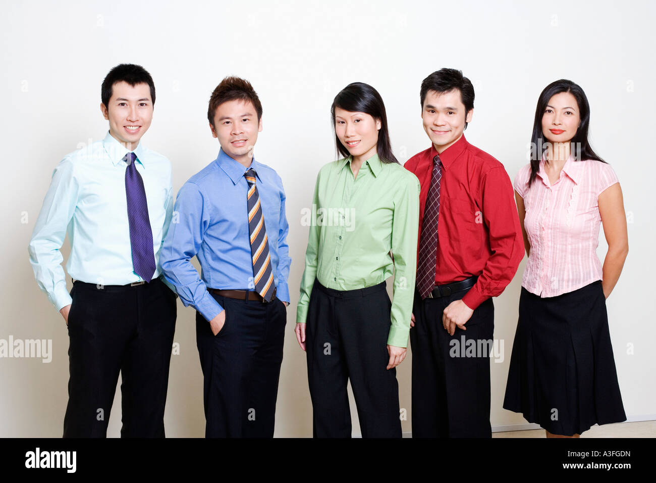 Portrait of five business executives standing together and smiling ...
