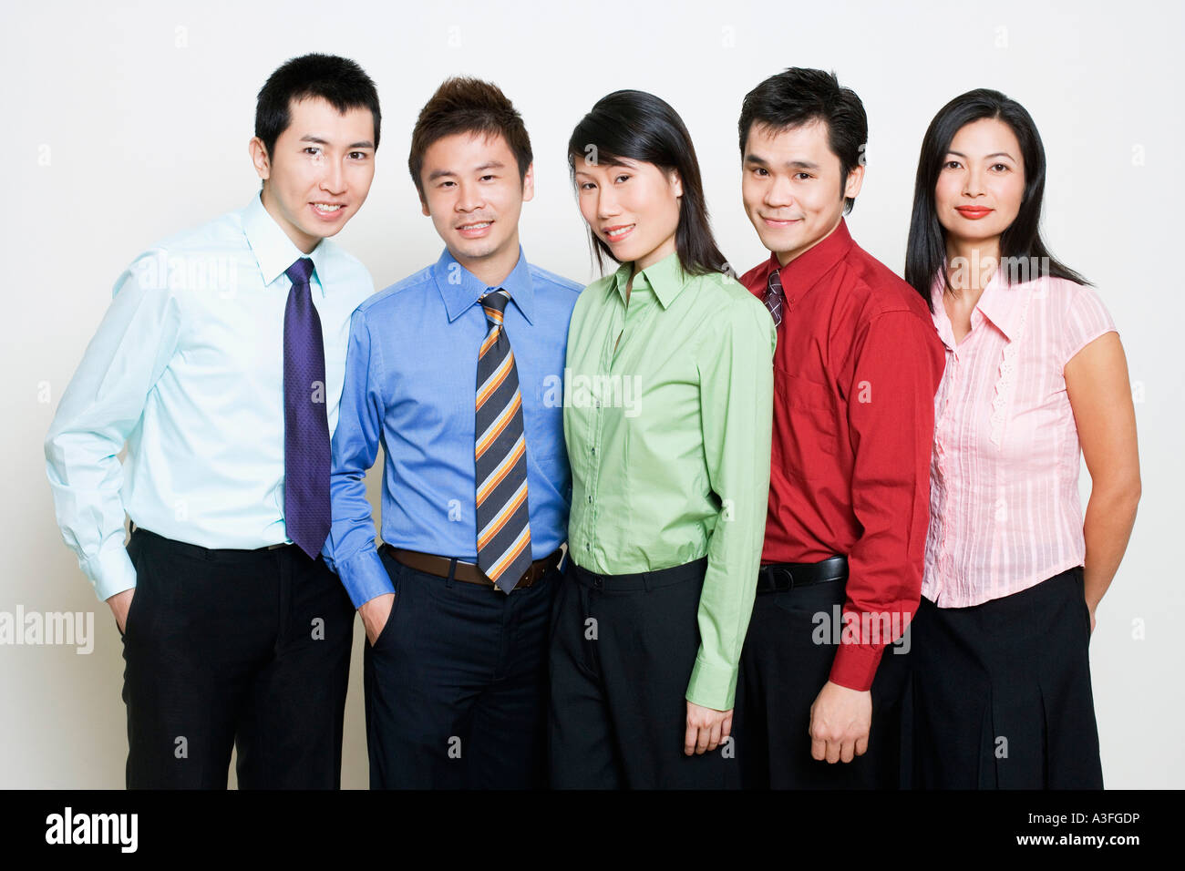 Portrait of five business executives standing together and smiling ...