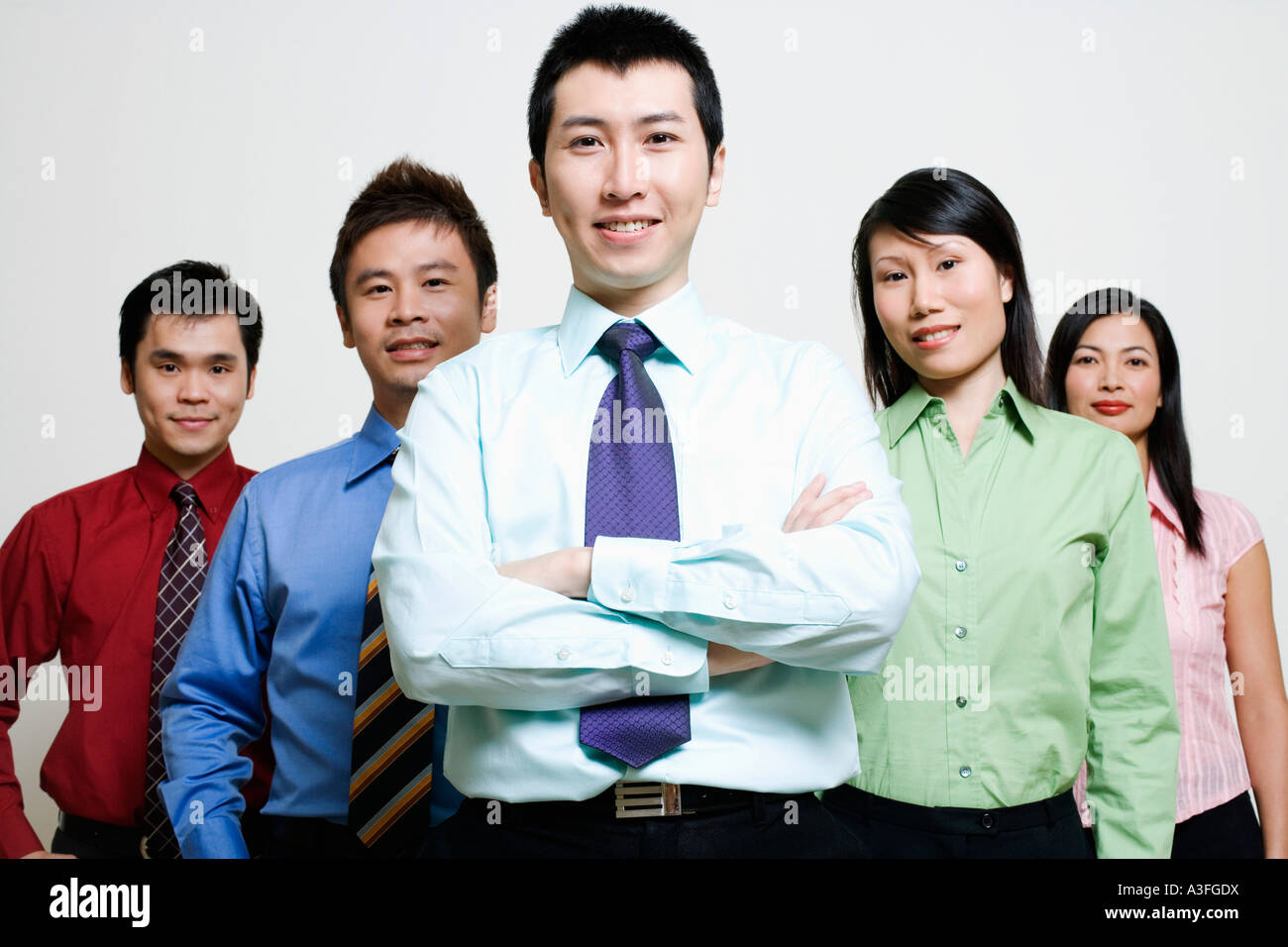 Portrait of five business executives standing together and smiling ...