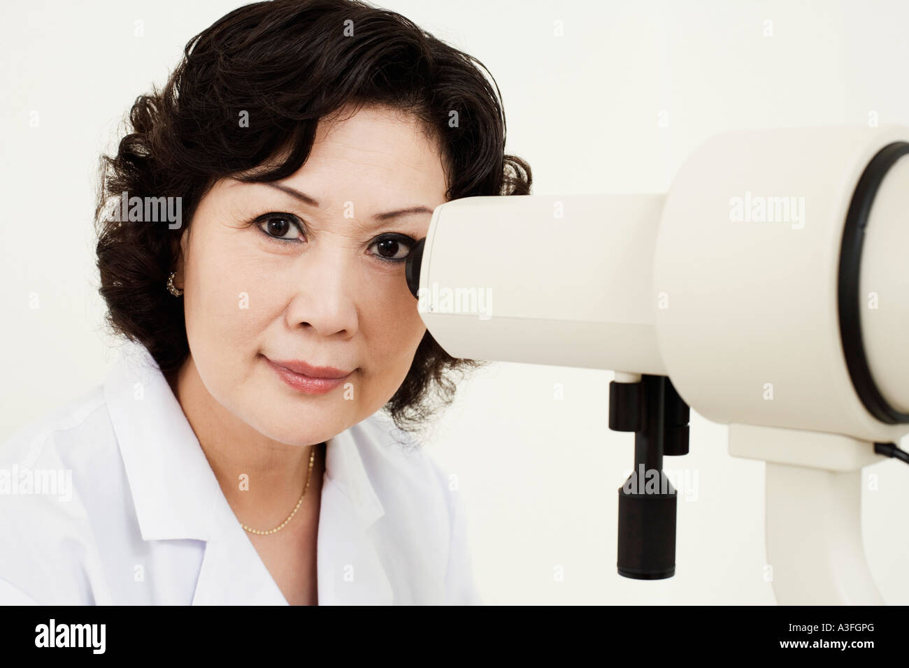 Portrait of an optometrist in front of an ophthalmoscope Stock Photo