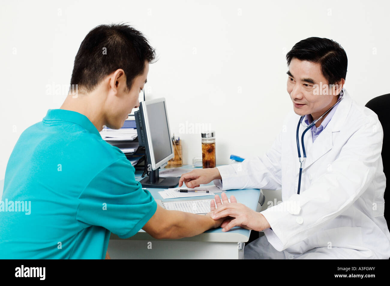 Male doctor checking a patient's pulse Stock Photo