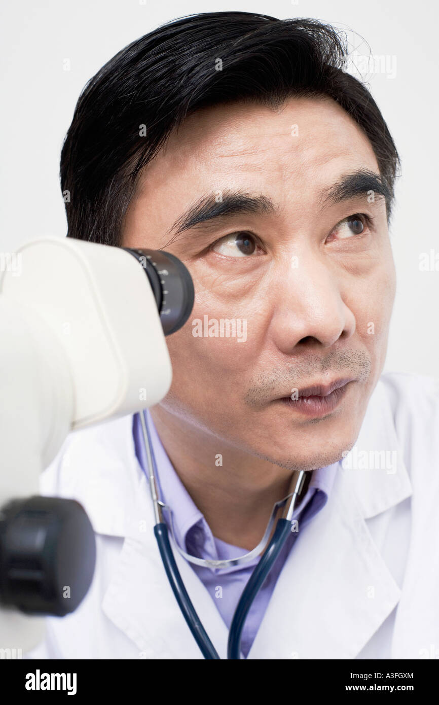 Closeup of an optometrist in front of an ophthalmoscope Stock Photo