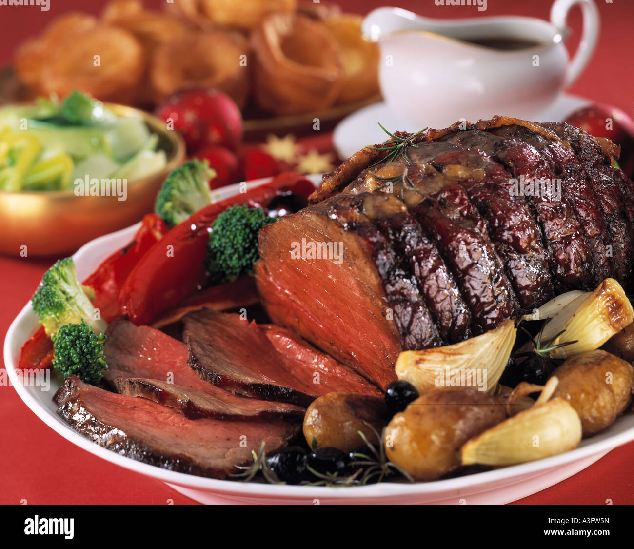 Whole roast beef topside joint with vegetables and Yorkshire puddings