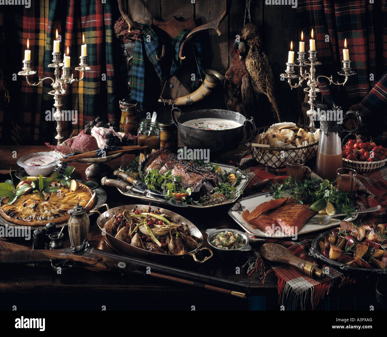 Scottish hunting lodge feast venison grouse smoked salmon pheasant roast potatoes and apple tart editorial food Stock Photo