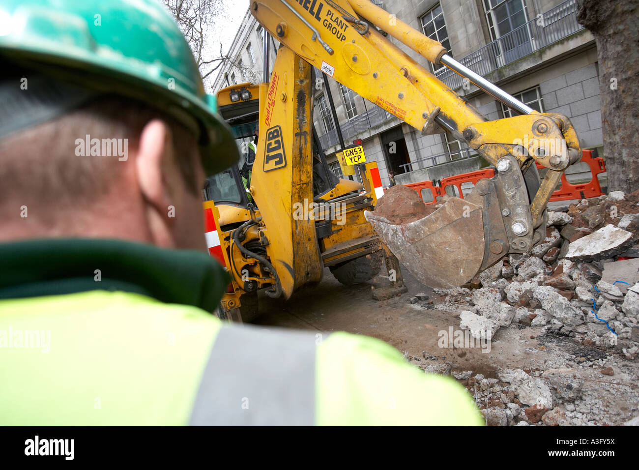 Workman digging up the road Stock Photo Alamy