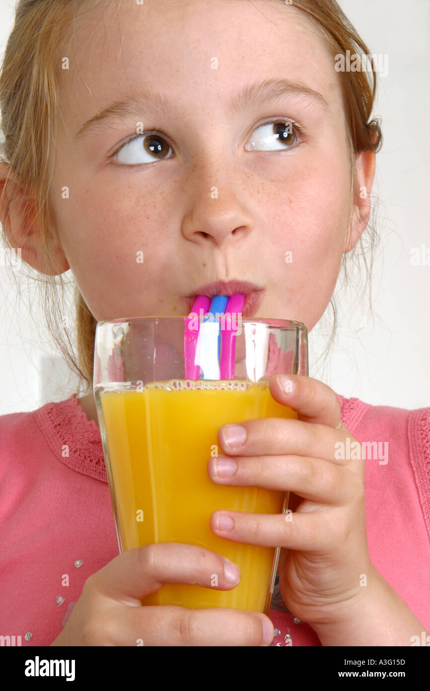 Girl drinking orange juice with straw Stock Photo Alamy