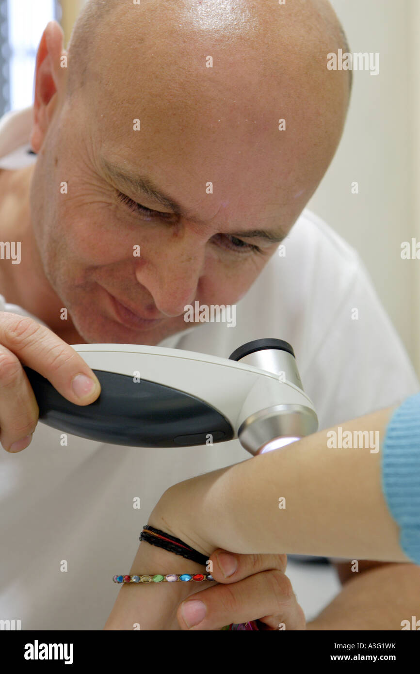 The skin specialist MD Serko von Schmiedeberg examines a patient with a dermatoscope Stock Photo