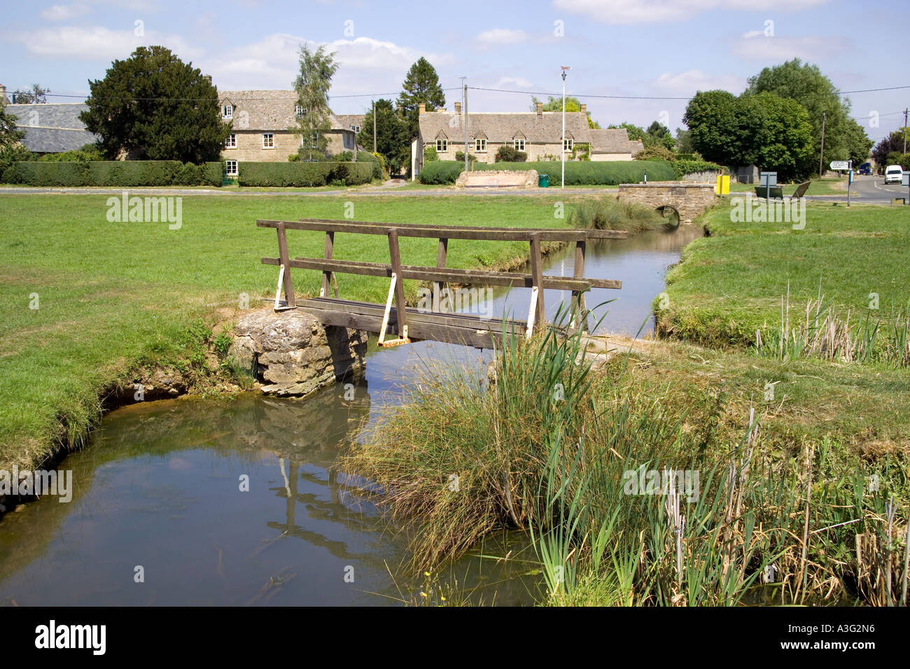 The stream running through the village green in the Cotswold village of Bledington, Gloucestershire UK Stock Photo