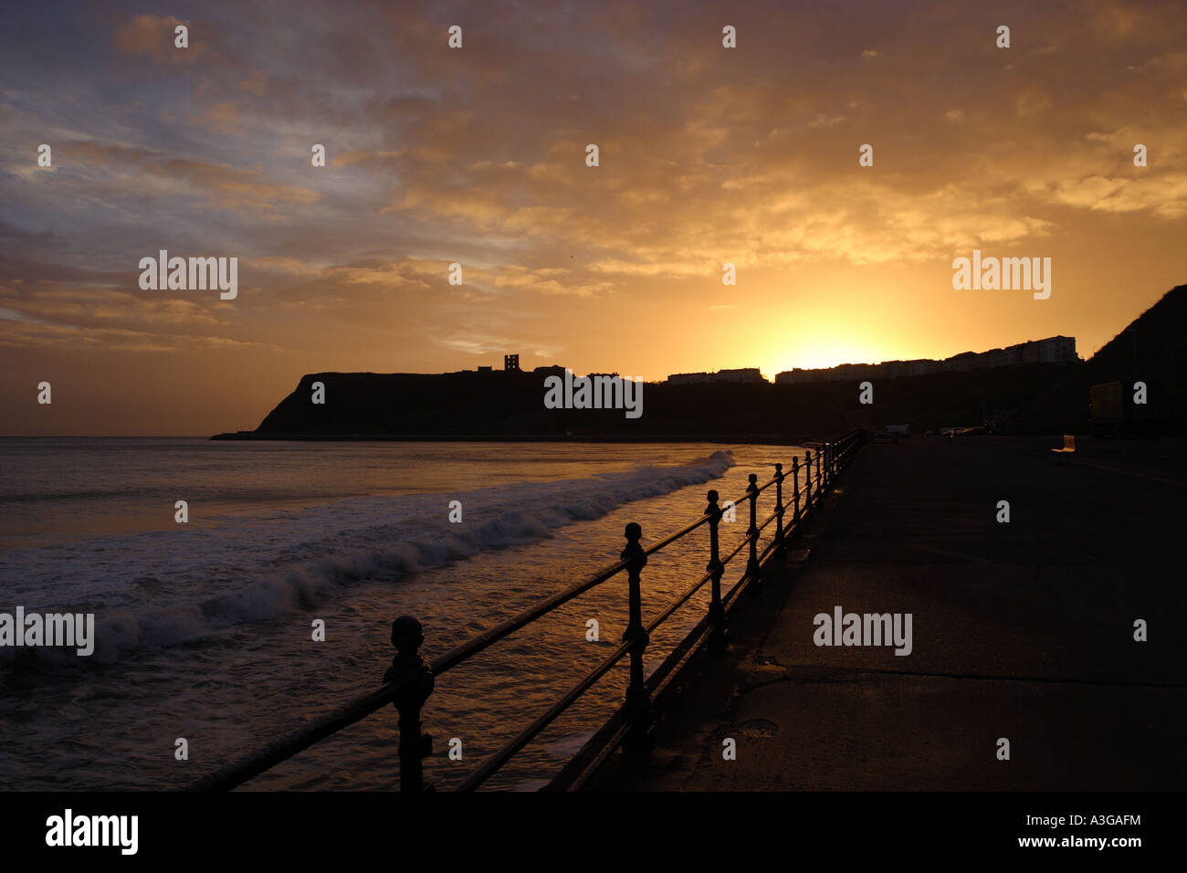 Sunrise over Scarborough castle headland as seen from the Marine Drive and North Bay. Waves
