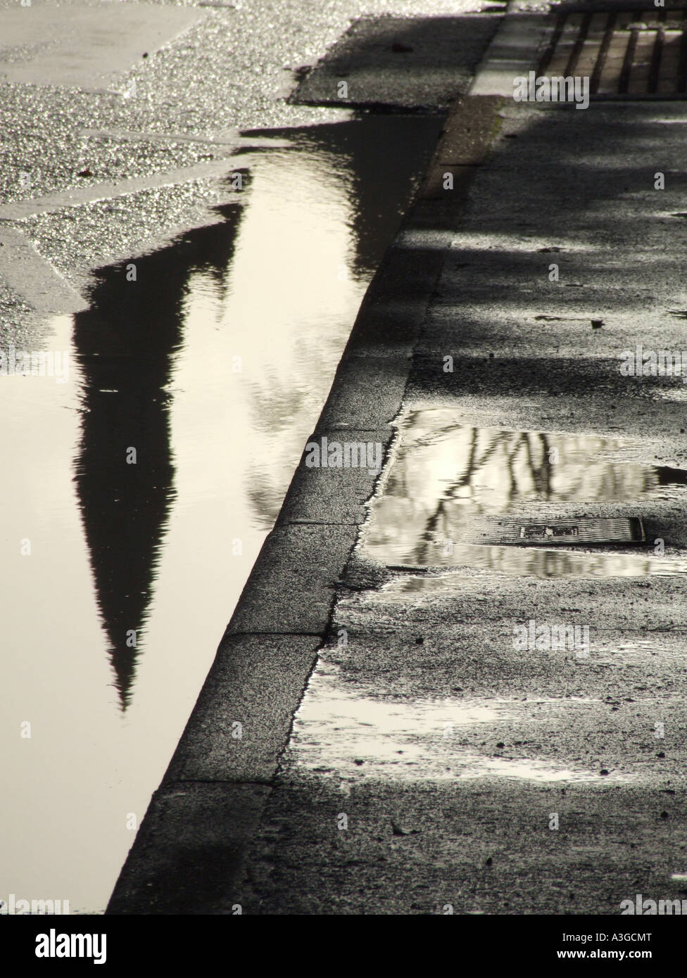 building reflected in a puddle of water on wet street Stock Photo - Alamy