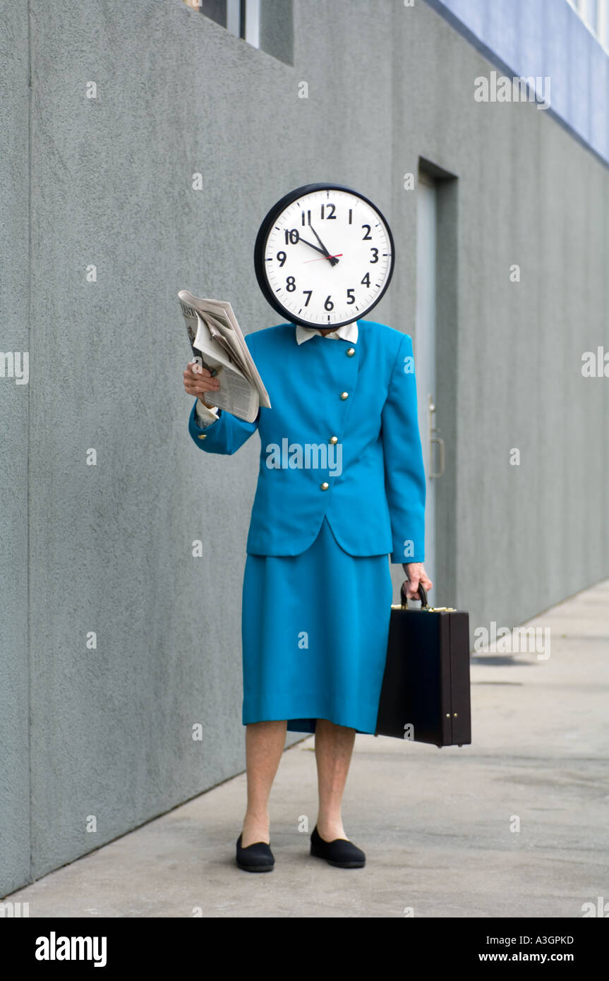 conceptual view of business woman on sidewalk with large clock replacing her head Stock Photo
