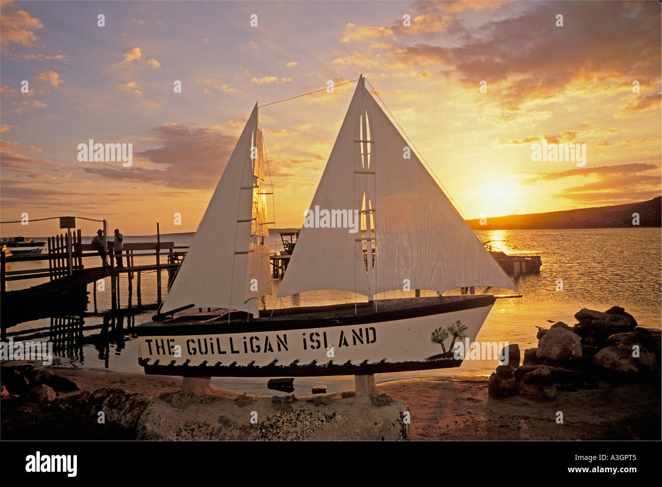 Boat advertising Gilligans Island and men standing on the dock at San Jacinto Guanica Puerto Rico Stock Photo