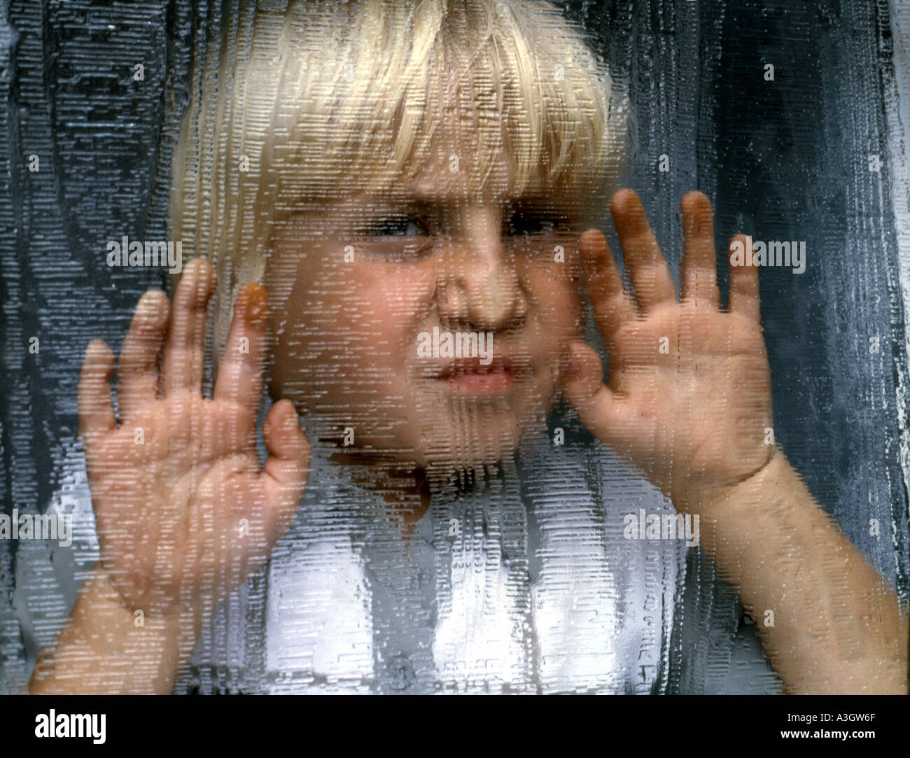 Male child looking through patterned glass door Stock Photo Alamy