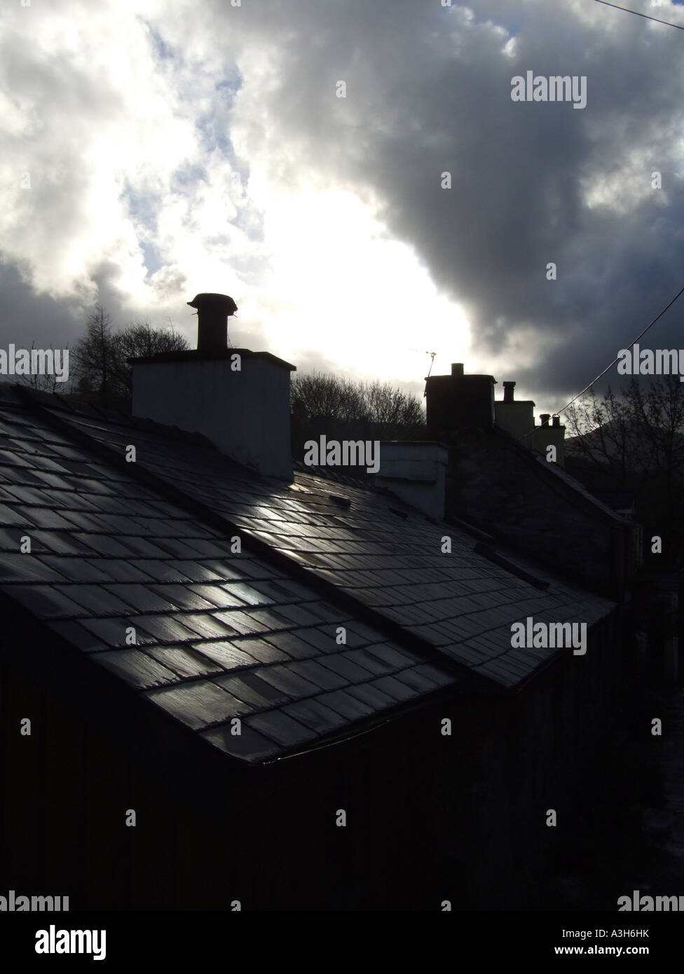 backlit council house roof in countryside with dramatic sky Stock Photo