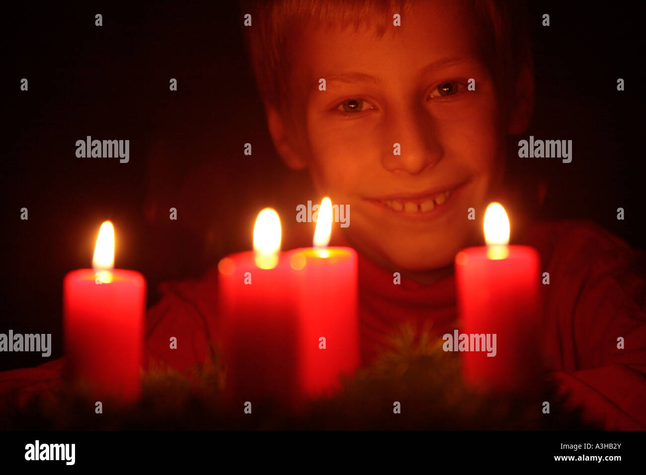 young boy looking happily at the candles of an Advent wreath Stock Photo