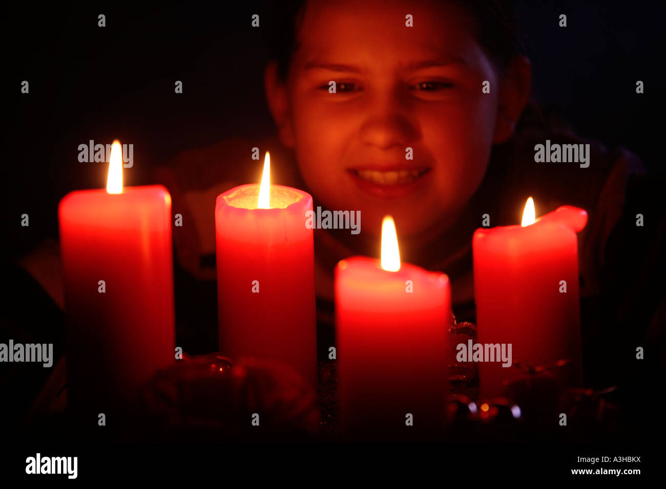 young girl looking happily at the candles of an Advent wreath Stock Photo