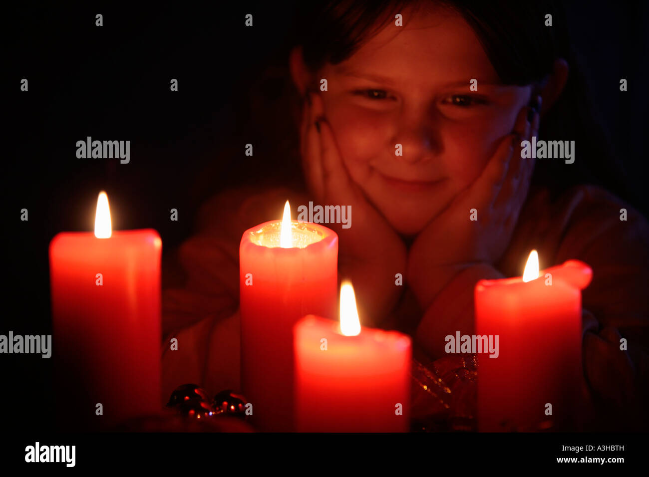 young girl looking happily at the candles of an Advent wreath Stock Photo