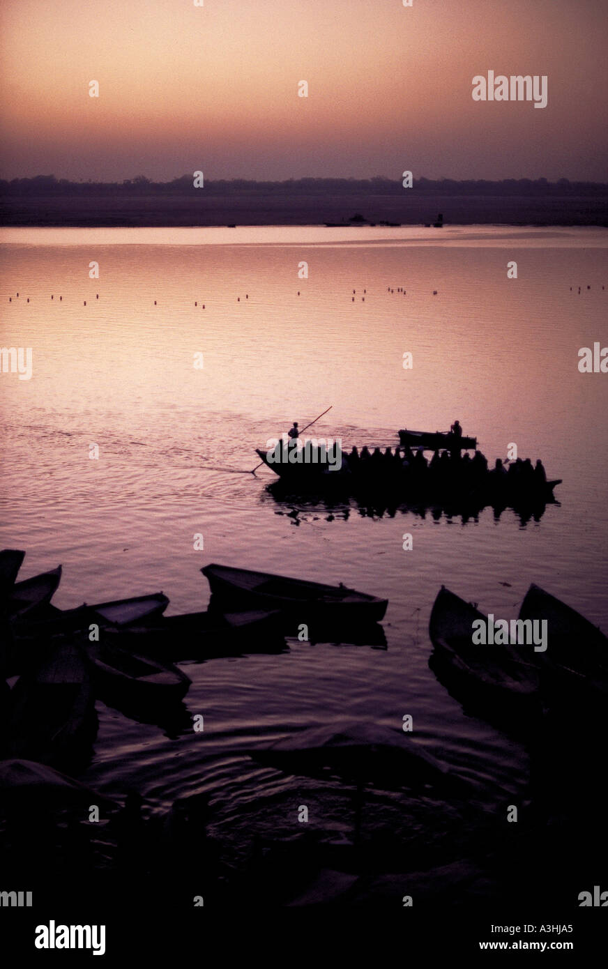 ferryboat acrossing ganga river at evening near city of varanasi state of uttar pradesh india Stock Photo