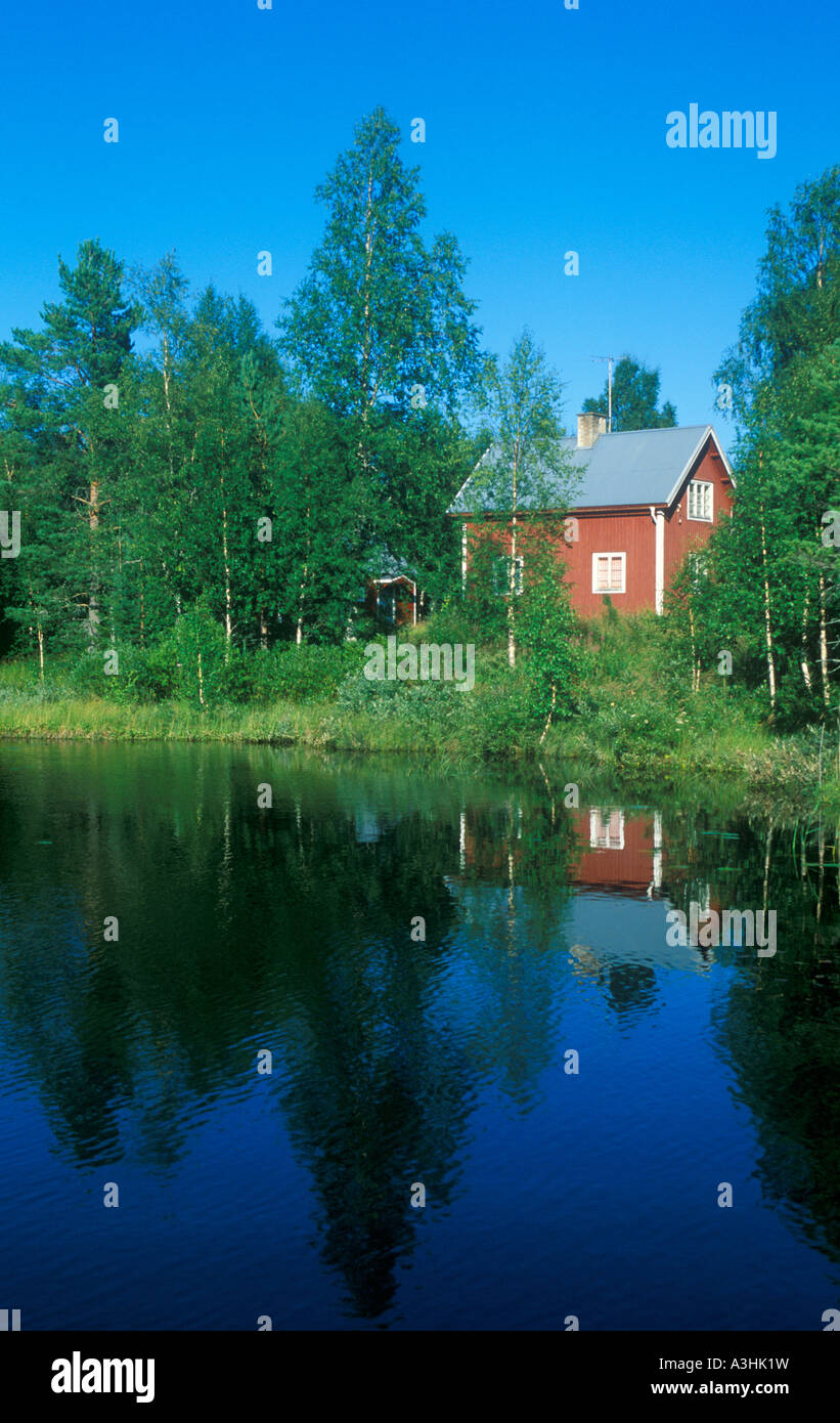 typical red wooden house at a lake in Central Sweden Stock Photo