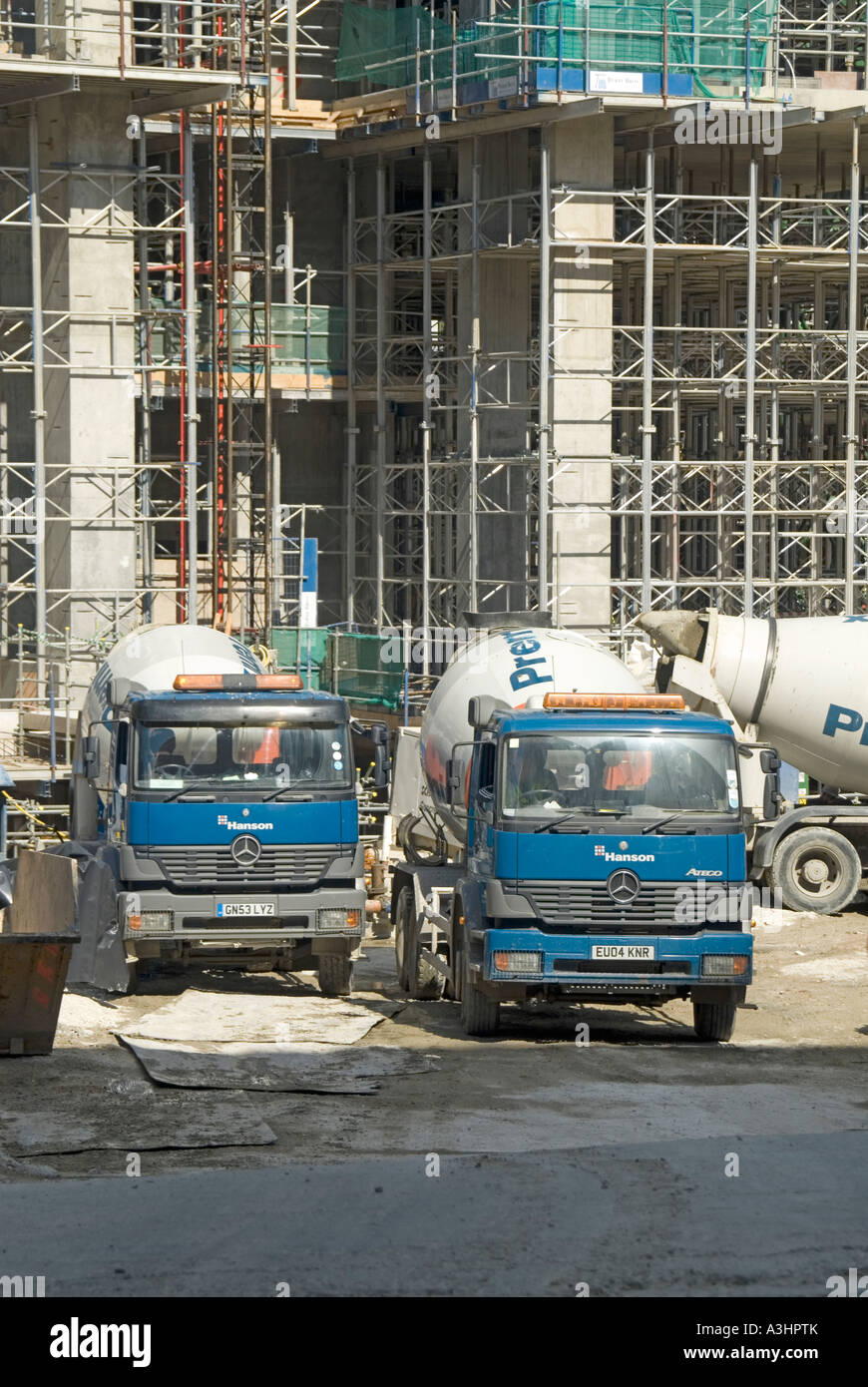 Hanson Mercedes readymix concrete delivery trucks parked awaiting unloading on construction site Stock Photo