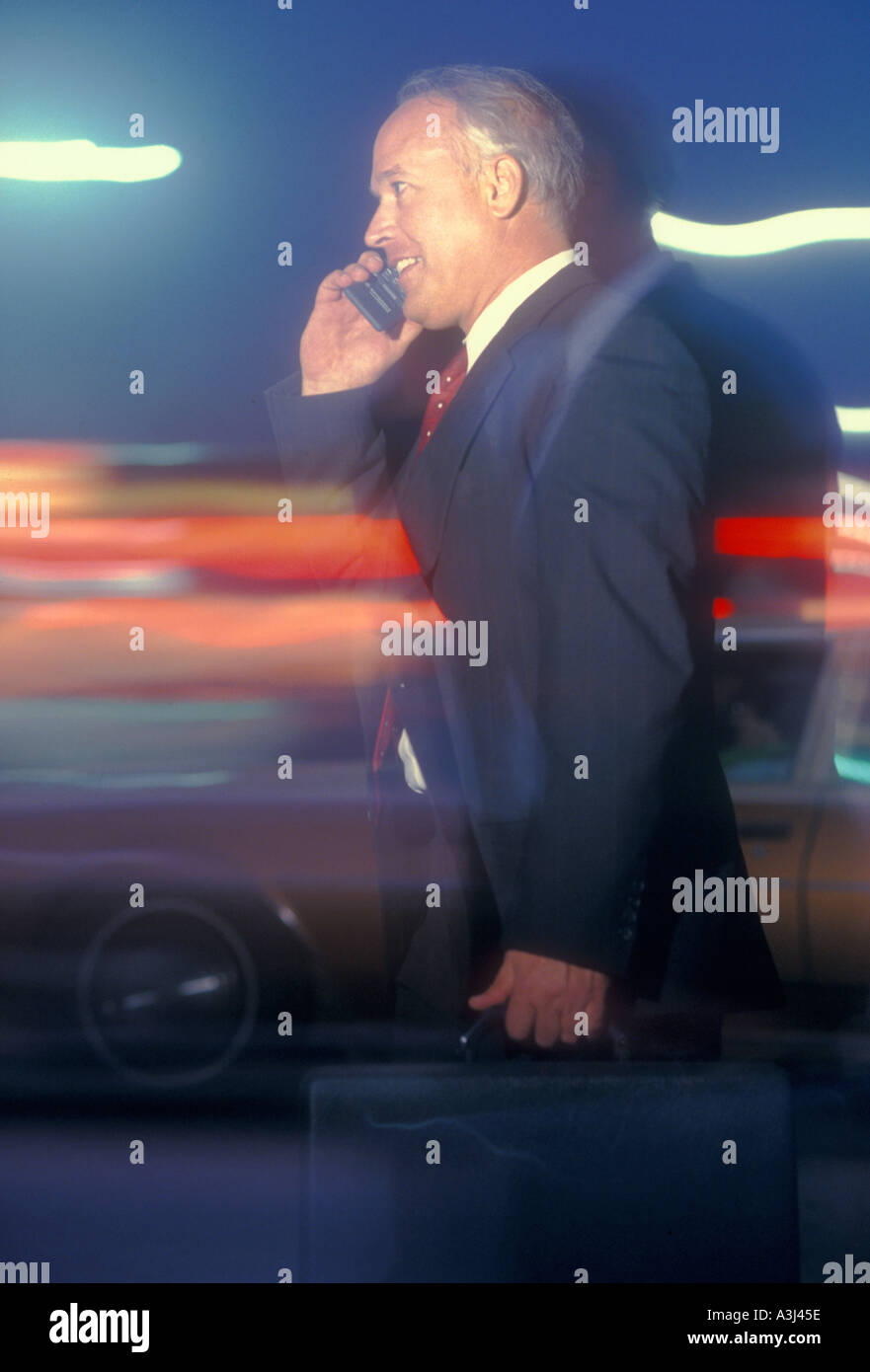businessman talking on cell phone while rushing to work Stock Photo
