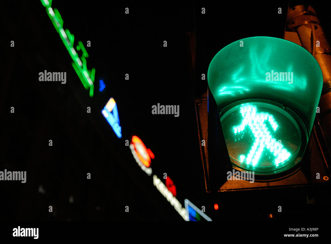 Illuminated crosswalk green traffic light for pedestrian at night Stock Photo