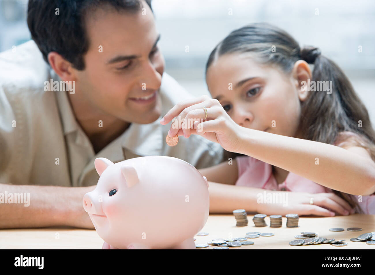 Father and daughter with piggy bank Stock Photo - Alamy