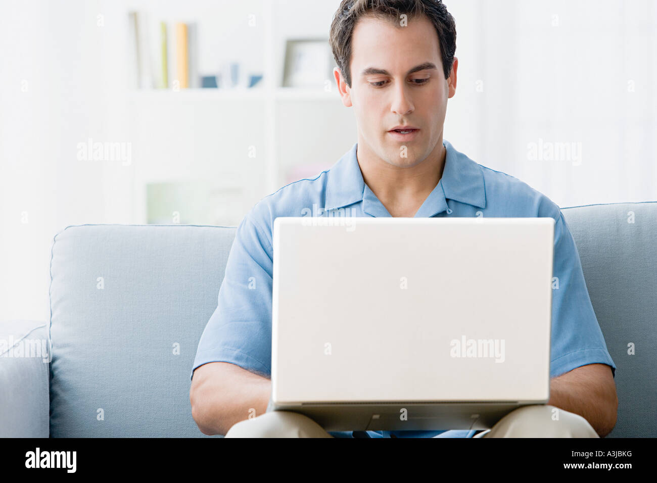 Man using a laptop computer at home Stock Photo - Alamy