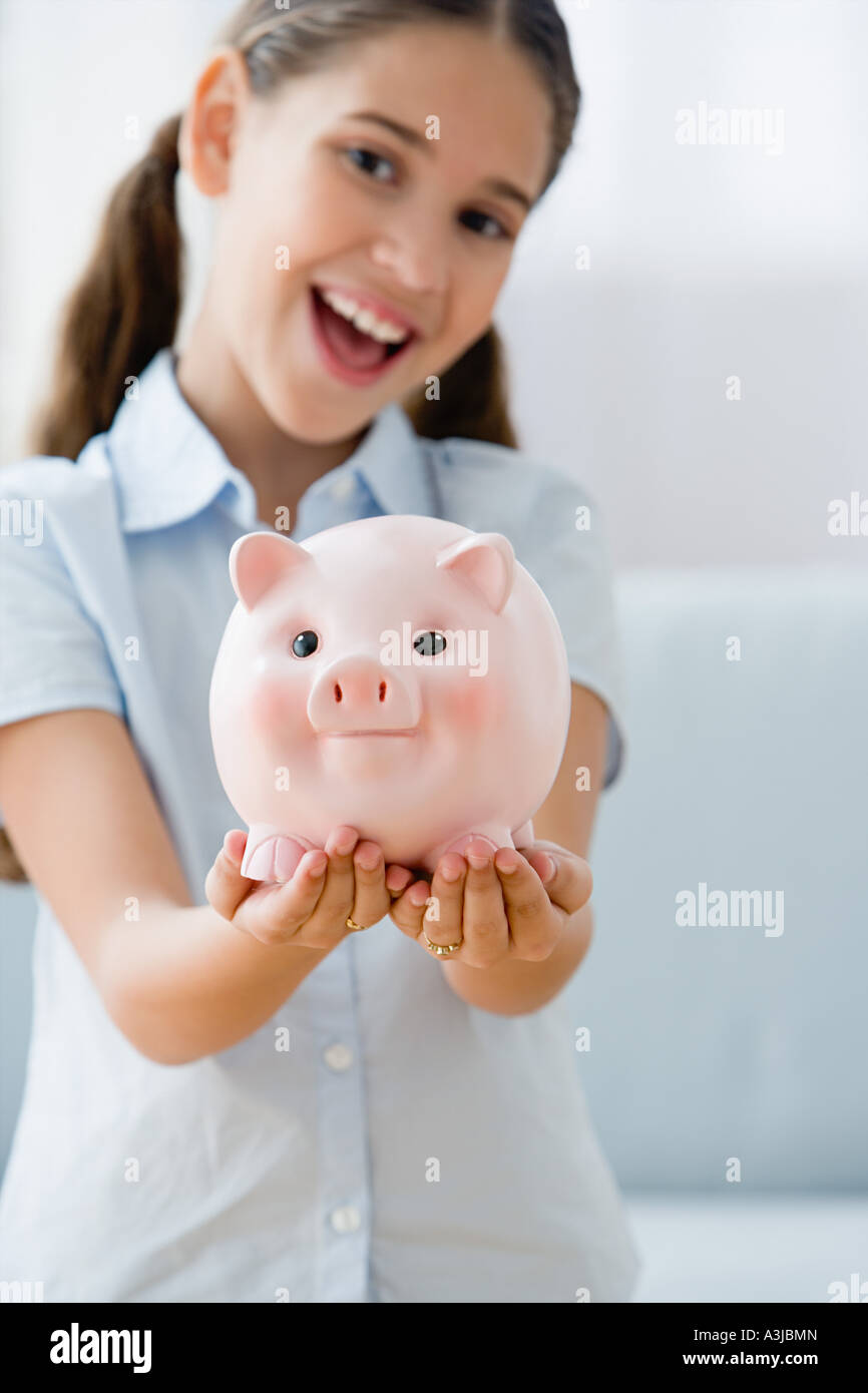 Smiling girl holding a piggy bank Stock Photo - Alamy