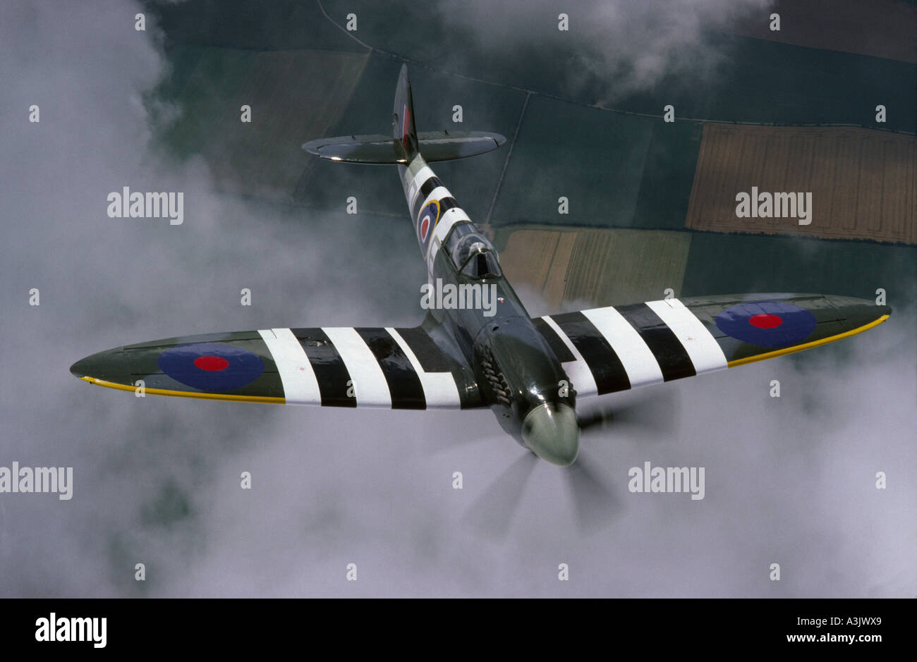 Supermarine Spitfire bearing Invasion stripes in flight Stock Photo